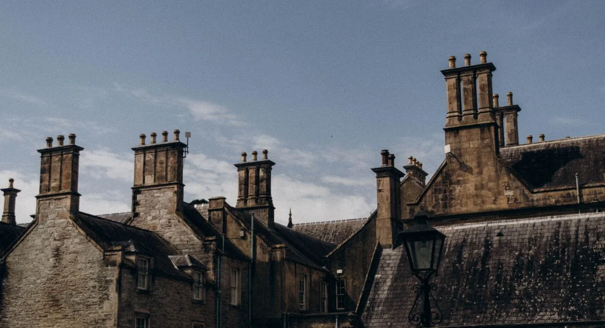 A captivating view of historic Gothic brick buildings with tall chimneys under a clear sky.