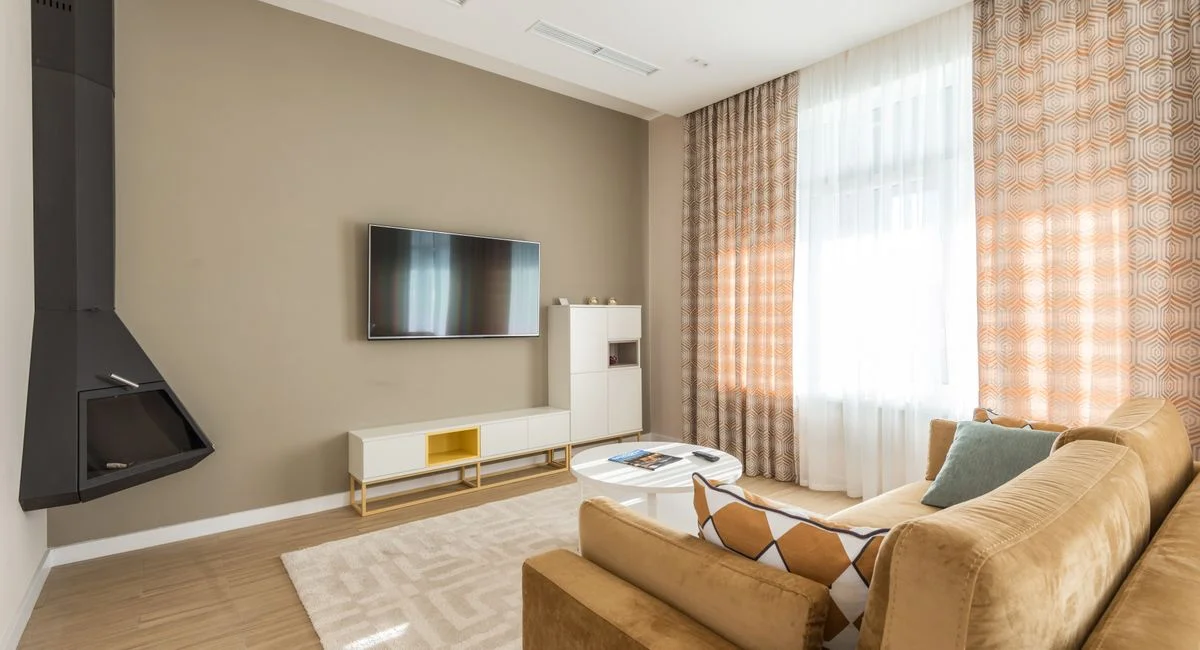 Stylish living room featuring a beige sofa, modern decor, and wall-mounted TV.