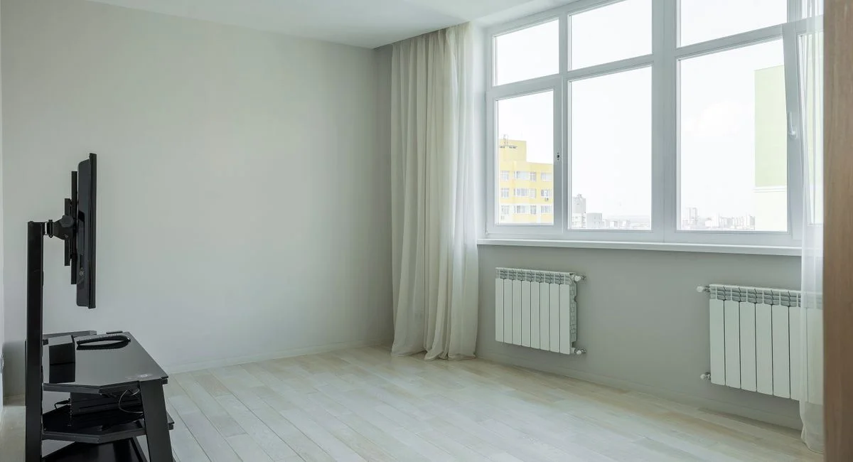 Spacious and bright minimalist apartment with large windows and hardwood floors.