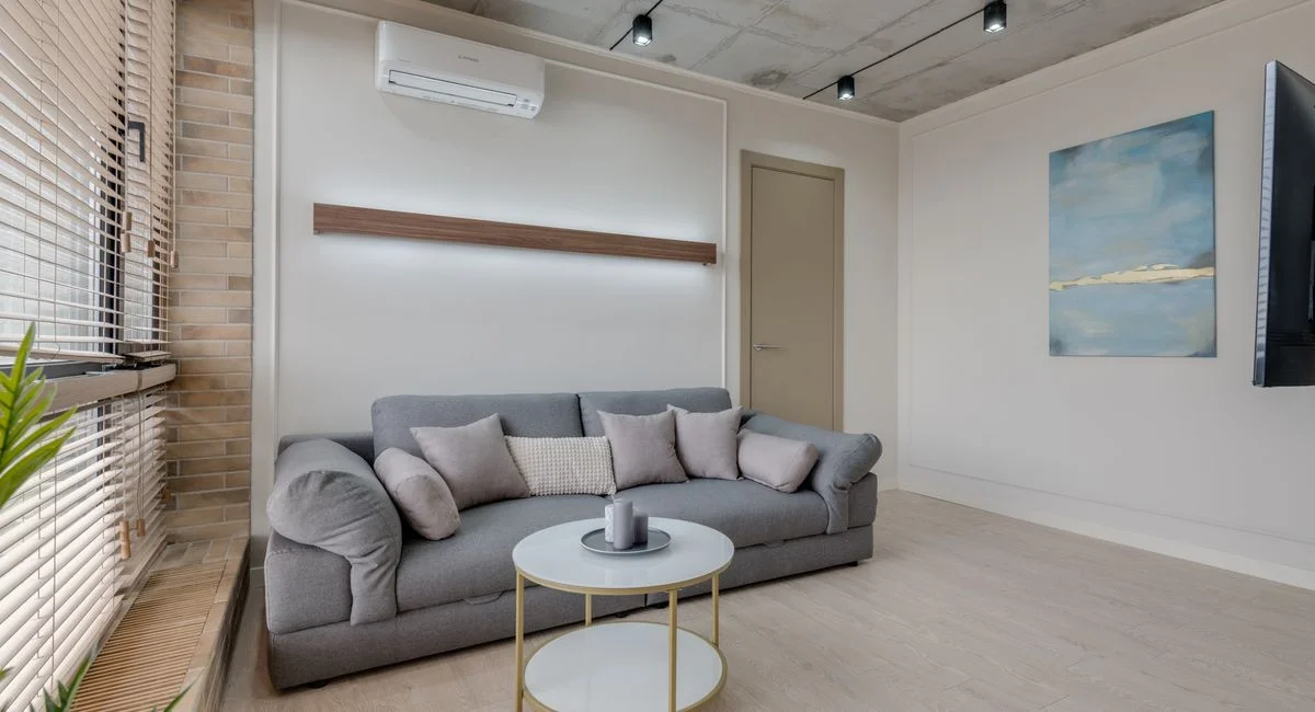 Stylish living room with a gray sofa, abstract art, and minimalist design.