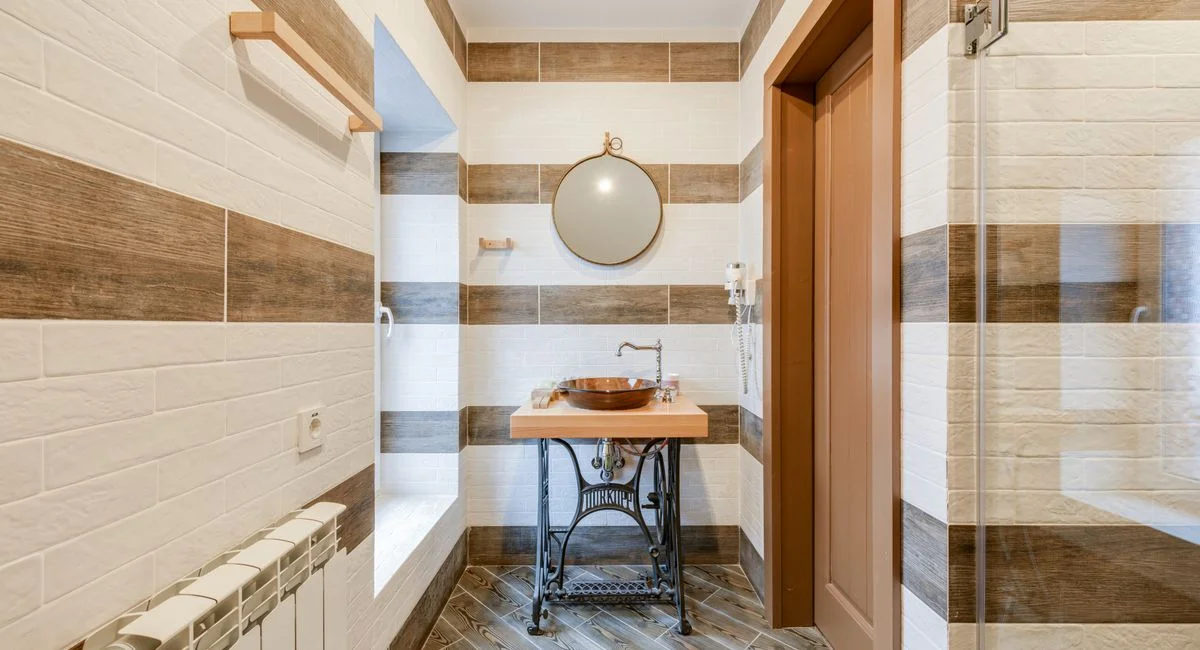 Stylish bathroom with upcycled sink table and round mirror.