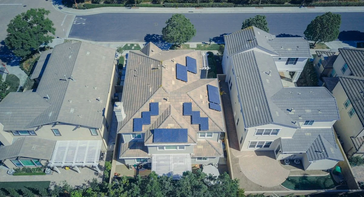 Aerial view of suburban houses equipped with solar panels for renewable energy.