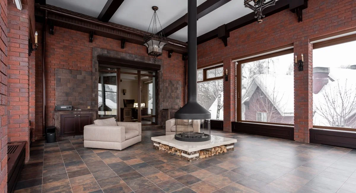 Elegant modern interior featuring a central fireplace and comfortable seating with large windows.