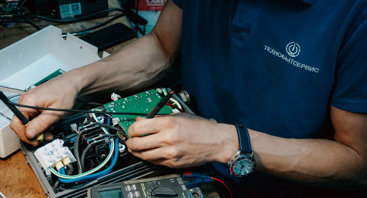 A technician methodically repairs a circuit board, showcasing expertise in electronics and technical skills.