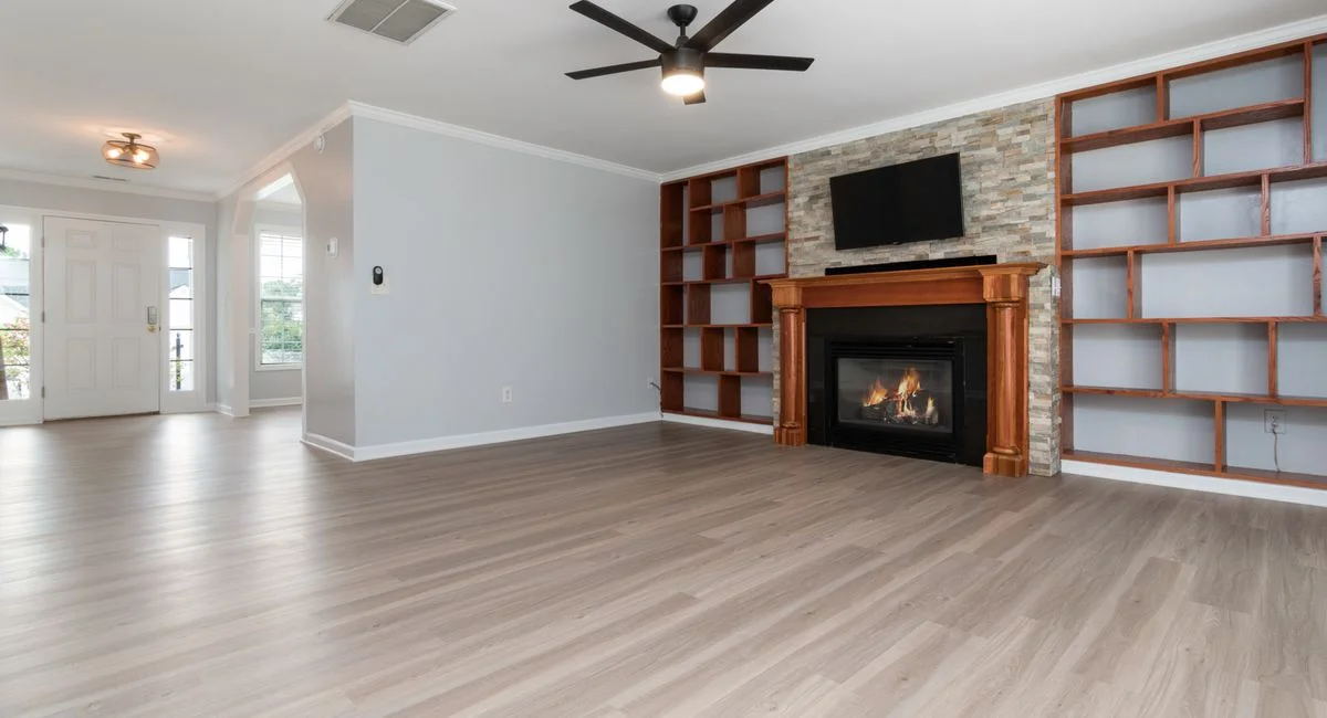 Bright, spacious living room with a modern fireplace and built-in shelves, perfect for home interiors.