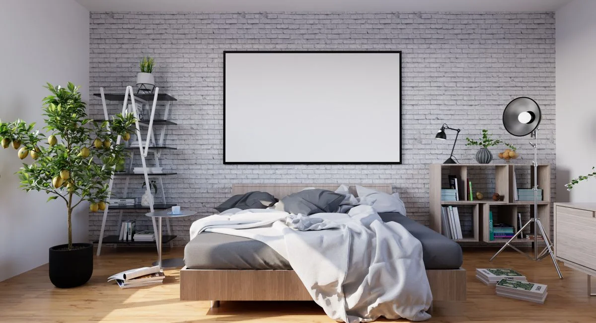 Stylish modern bedroom with minimalist decor, featuring a brick wall and natural lighting.