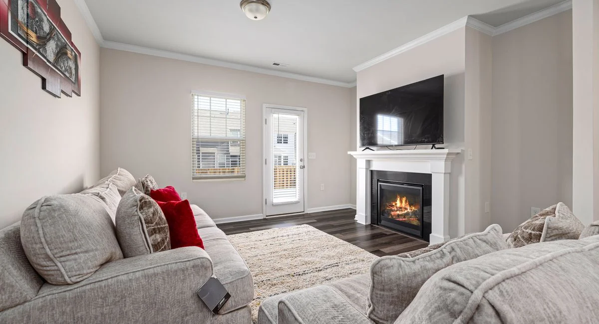 Cozy modern living room featuring a stylish fireplace and large TV for ultimate relaxation.