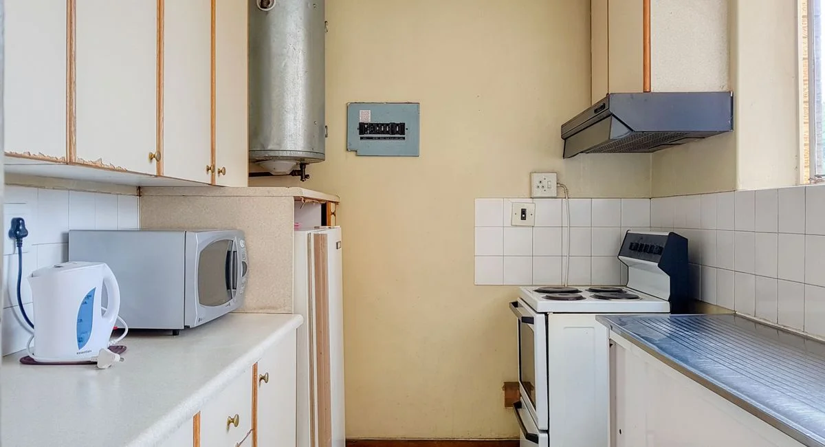 A compact kitchen featuring vintage appliances and contemporary design elements, perfect for a cozy home vibe.