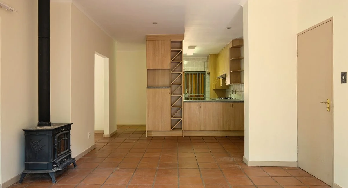Spacious living area with a modern kitchen, warm tones, and a wood-burning stove.