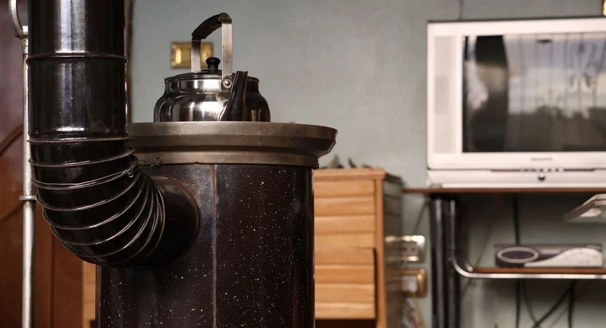 An vintage stove with a kettle beside a retro TV set, creating a nostalgic indoor ambiance.