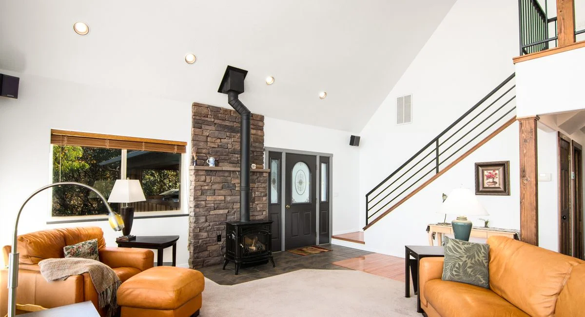 Bright and welcoming living room featuring a rustic fireplace and modern decor.