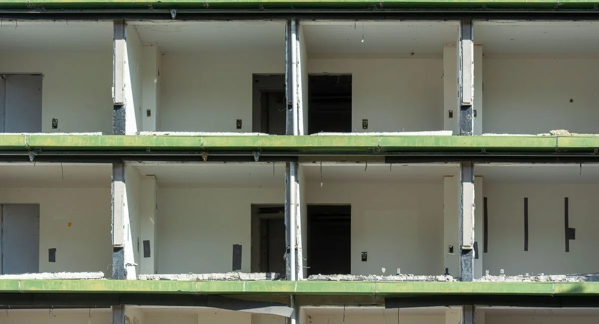 Close-up view of a partially demolished urban building showing exposed concrete and empty rooms.