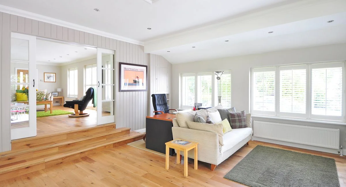 Spacious and bright modern living room with wooden floors and stylish furniture.
