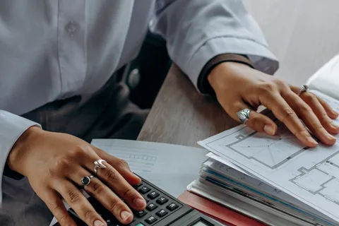 Une personne vérifie des documents avec une calculatrice